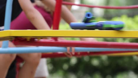 niños en el patio de recreo con carrusel girando