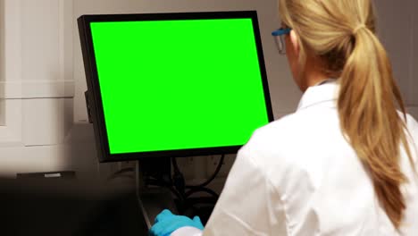 Scientist-using-computer-with-chroma-key-screen