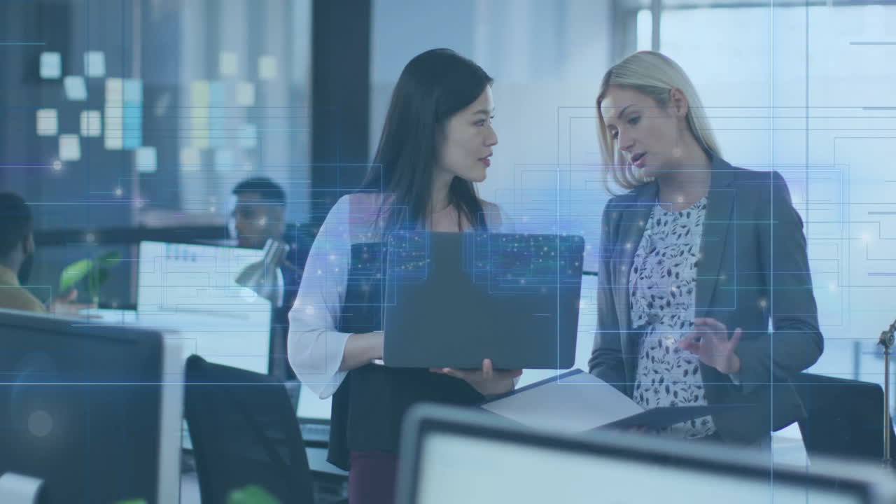 Discussing work, businesswomen with digital data overlay animation in modern office setting