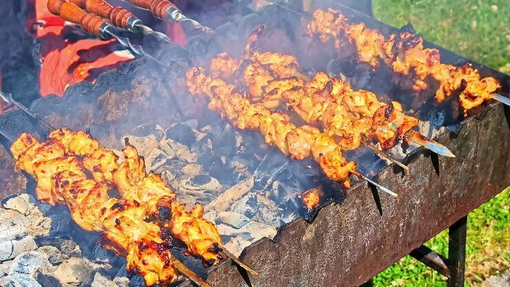Midday barbecue in hot sun, shish-kebab, cinematic garden kitchen perspective - Latvia