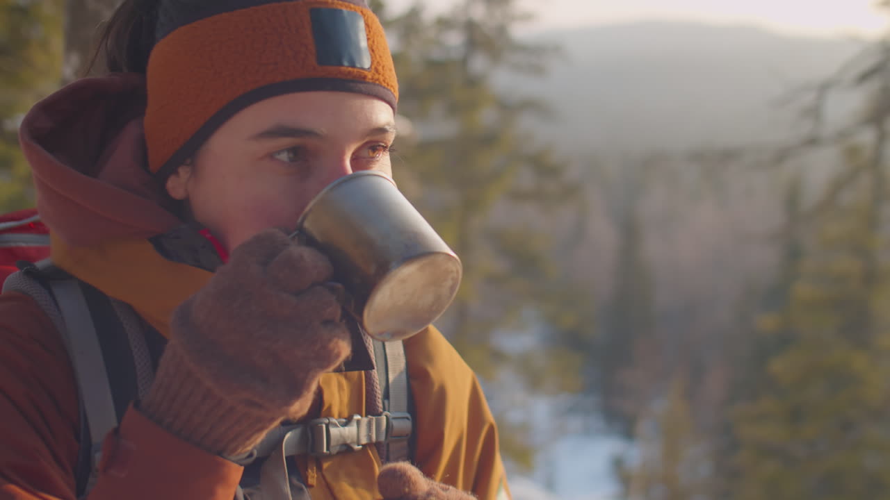 Female Tourist Drinking Hot Tea during Winter Hike