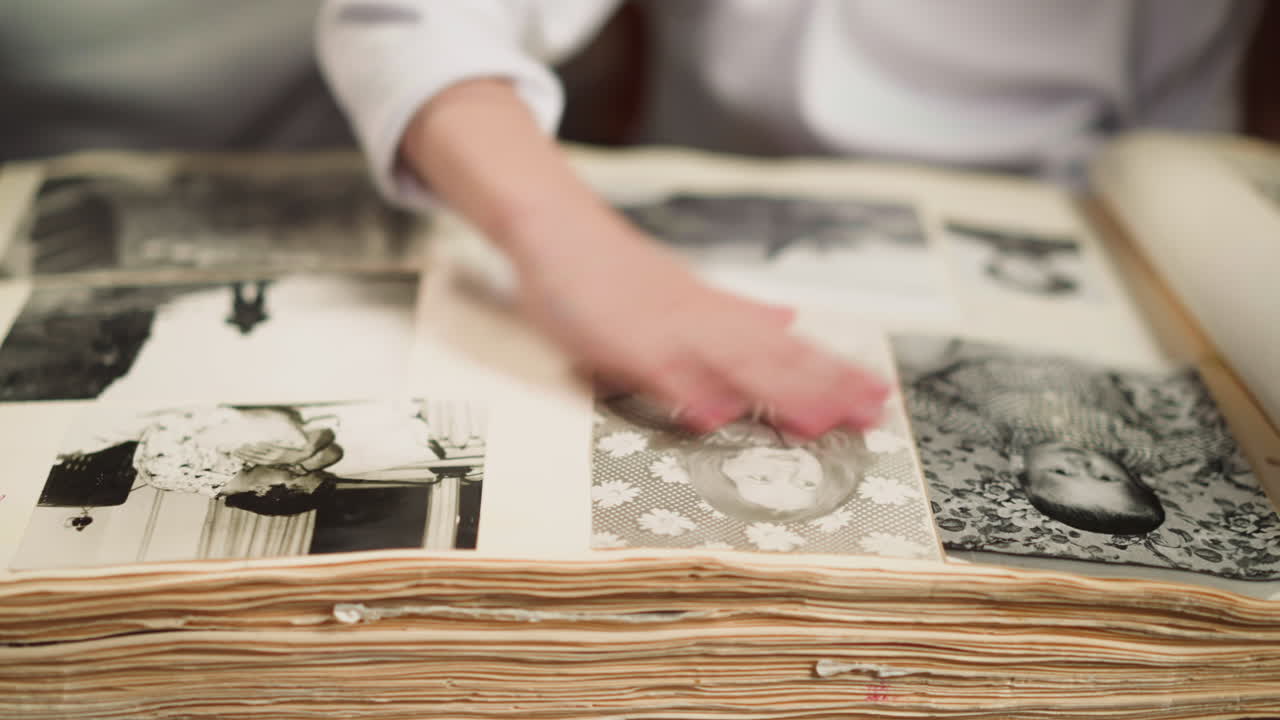 Girl wipes pale pictures of grandmother in old family album