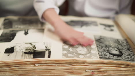 girl wipes pale pictures of grandmother in old family album