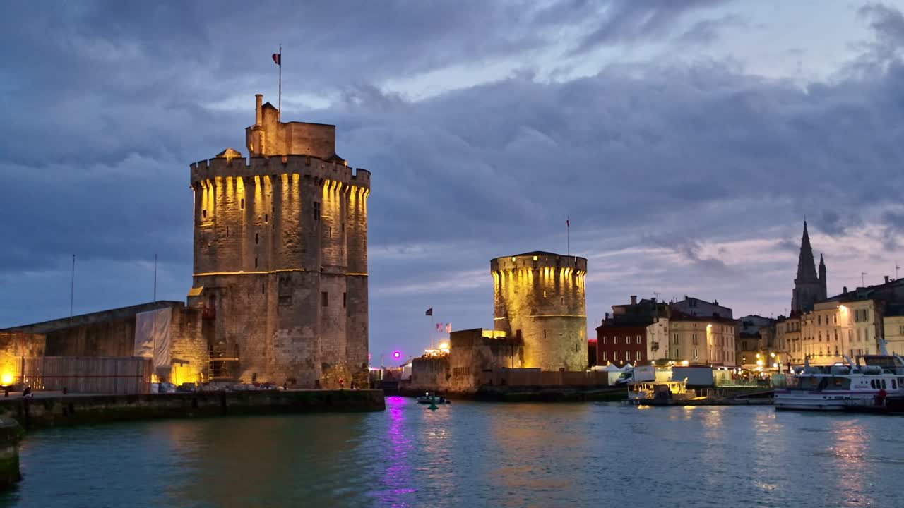 Beautiful La Rochelle's marina sunset night with docked boats and the Chain Tower with Lantern Tower, Charente-Maritime, France