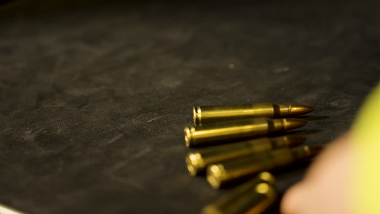 Across the frame, rounds of 5.56 roll.