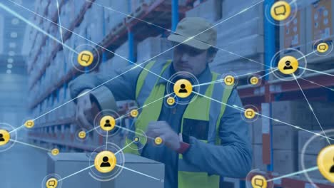 Animation-of-network-of-connections-with-icons-over-caucasian-male-worker-in-warehouse