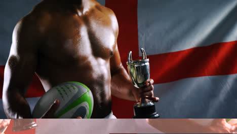 Deportista-De-Rugby-De-Inglaterra-Sosteniendo-Un-Trofeo-Y-Una-Pelota-De-Rugby-Contra-El-Fondo-De-La-Bandera-De-Inglaterra