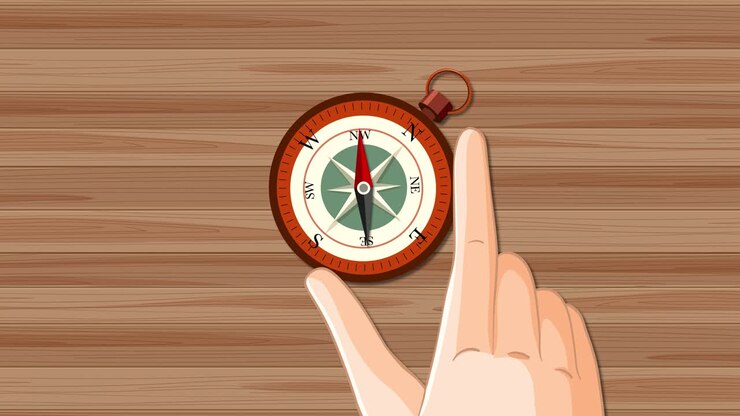 Hand interacts with compass on wooden surface
