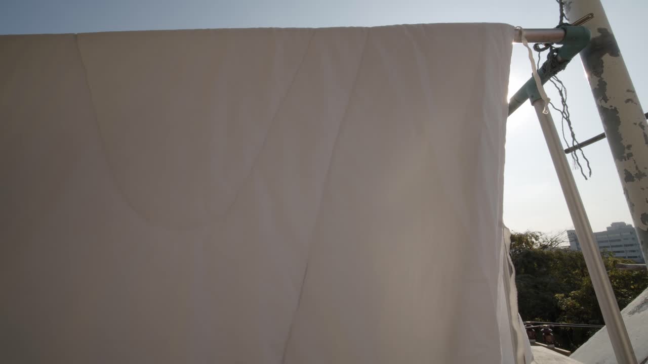 아파트 발코니에서 말리기 위해 침대 시트를 바람이 불면 햇빛이 반짝인다 - 정적으로 고립된 전망