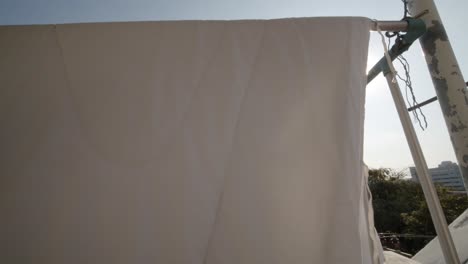 아파트 발코니에서 말리기 위해 침대 시트를 바람이 불면 햇빛이 반짝인다 - 정적으로 고립된 전망