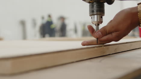 hombres perforando un pedazo de madera