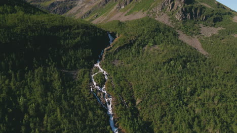 river with waterfalls in alpine landscape of northern norway, aerial dolly out