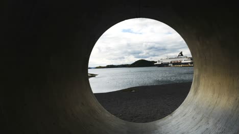 lake seen through concrete pipe on shore