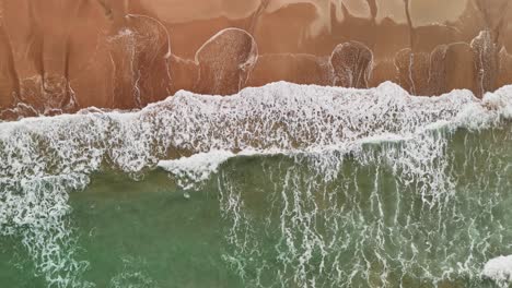 slow motion drone footage of waves on golden sand in lanta