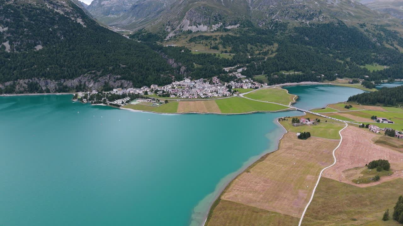 A tranquil lake near Silvaplana surrounded by mountains and meadows