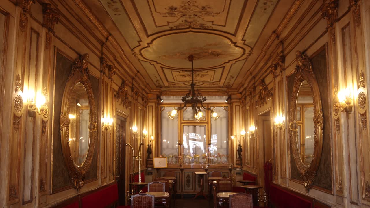 Classic Venetian cafe interior with ornate mirrors, chandeliers, and vintage decor