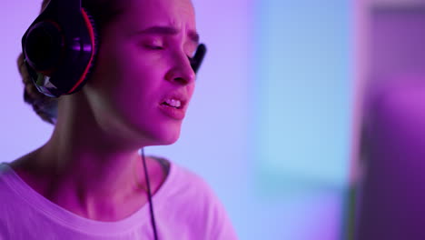 chica triste perdiendo ciberjuego en luces de neón primer plano. estudiante molesto fallando exámenes