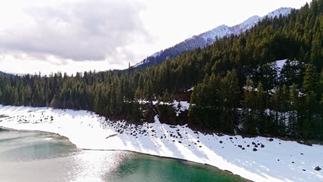 Scenic-view-of-snow-bank-of-Lake-Kachess-and-evergreen-forest-in-Washington-State