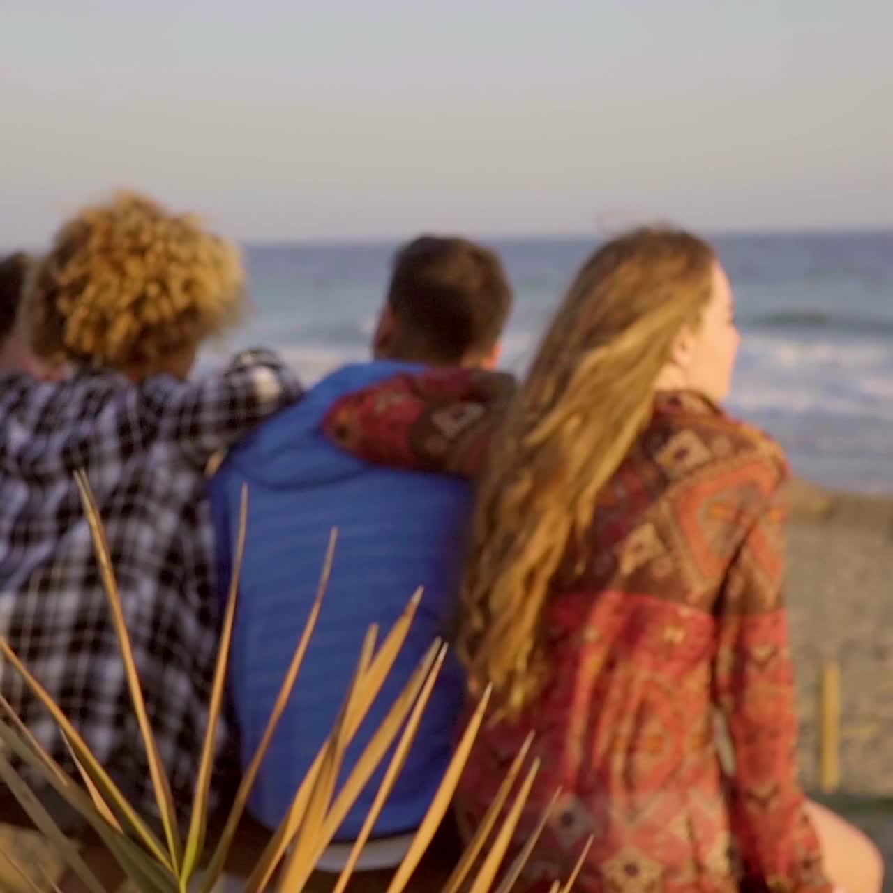 나무 울타리에 앉아있는 젊은이들