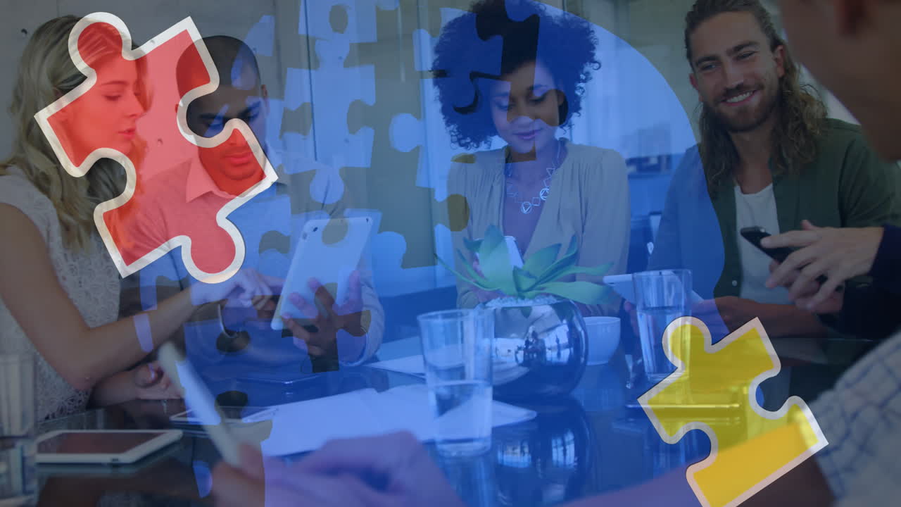 Animation of colourful puzzle pieces over work colleagues using tablets