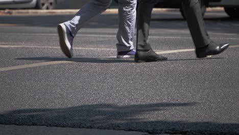 vista de ángulo bajo de las piernas de tres personas cruzando la calle