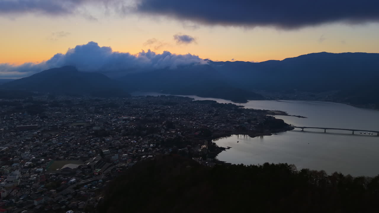 Aerial drone view of boats moving on Lake Kawaguchiko near the Fujikawaguchiko town, Japan at blue hour