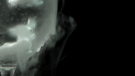 dry ice bubbling in a glass of champagne at black background