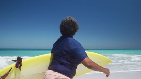 Senior-woman-walking-with-surfboard