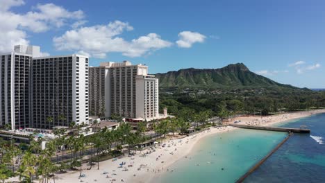 wide aerial push-in shot of the diamond head volcanic formation from waikiki beach on the island of o'ahu, hawaii