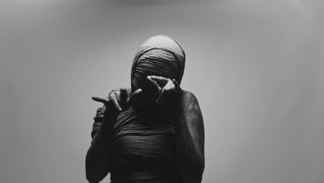 a mummified woman against the bright background moves erratically