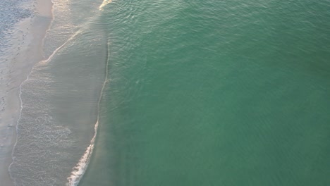 Vista-Aérea-De-Las-Olas-Del-Golfo-De-México-En-Pensacola,-Florida-Beach-Pan-Hasta-El-Amanecer-Y-Nubes-Esponjosas