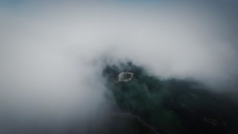 Cinematic-FPV-drone-shot-stabilized-from-lofoten-flying-over-small-island-covered-by-clouds