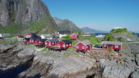 fantastic orbital shot of the pretty red houses of the town of hamnoy with mountains in the landscape