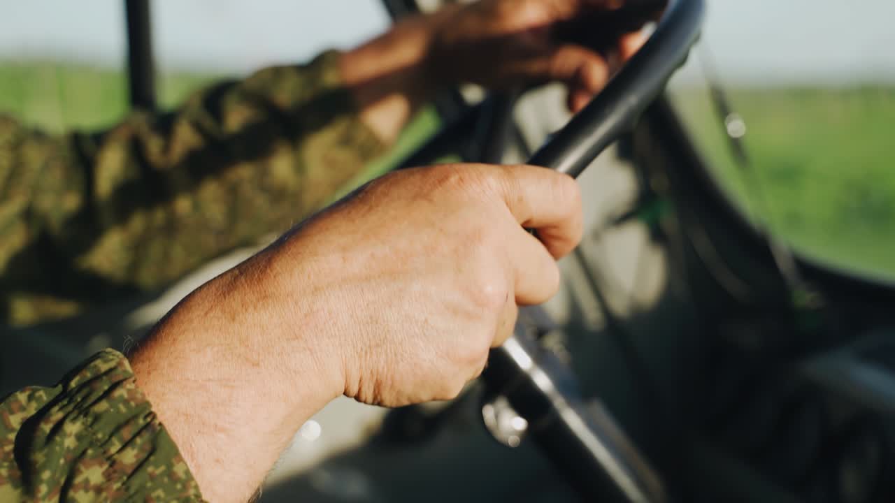 The driver drives the truck holding the steering wheel. The car is driving along a country road with pits. The whole car is shaking violently