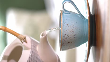 Vertikales-Video---Gießen-Von-Frischem-Kräutertee-Aus-Der-Kanne-In-Eine-Blaue-Vintage-Tasse