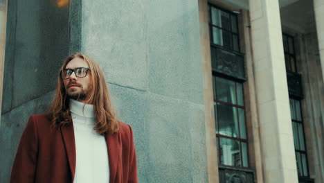 atractivo hombre hipster barbudo en abrigo de moda rojo