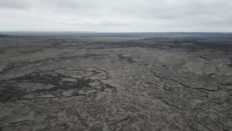 Approaching-high-altitude-drone-shot-of-the-The-Reykjanes-Peninsula-lava-fields-on-a-cloudy-overcast-day