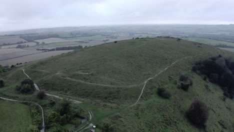 AERIAL---South-Downs-Way-and-hill,-East-Sussex,-United-Kingdom,-wide-spinning-shot