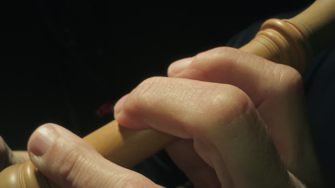 플루트 연주, 카메라가 왼쪽으로 뒤로 이동, 매우 근접, 느린 동작, 어두운, 노란 나무