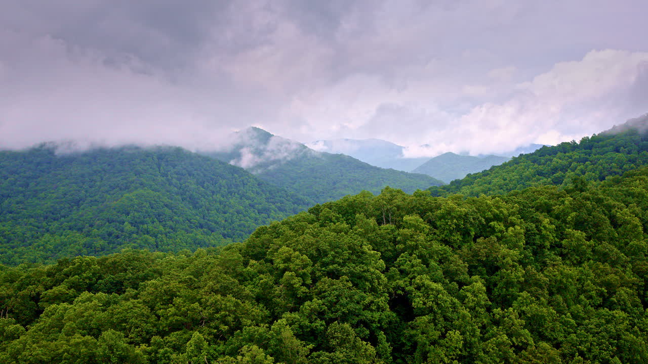 Drone view of smoky ridgelines fading into mist.