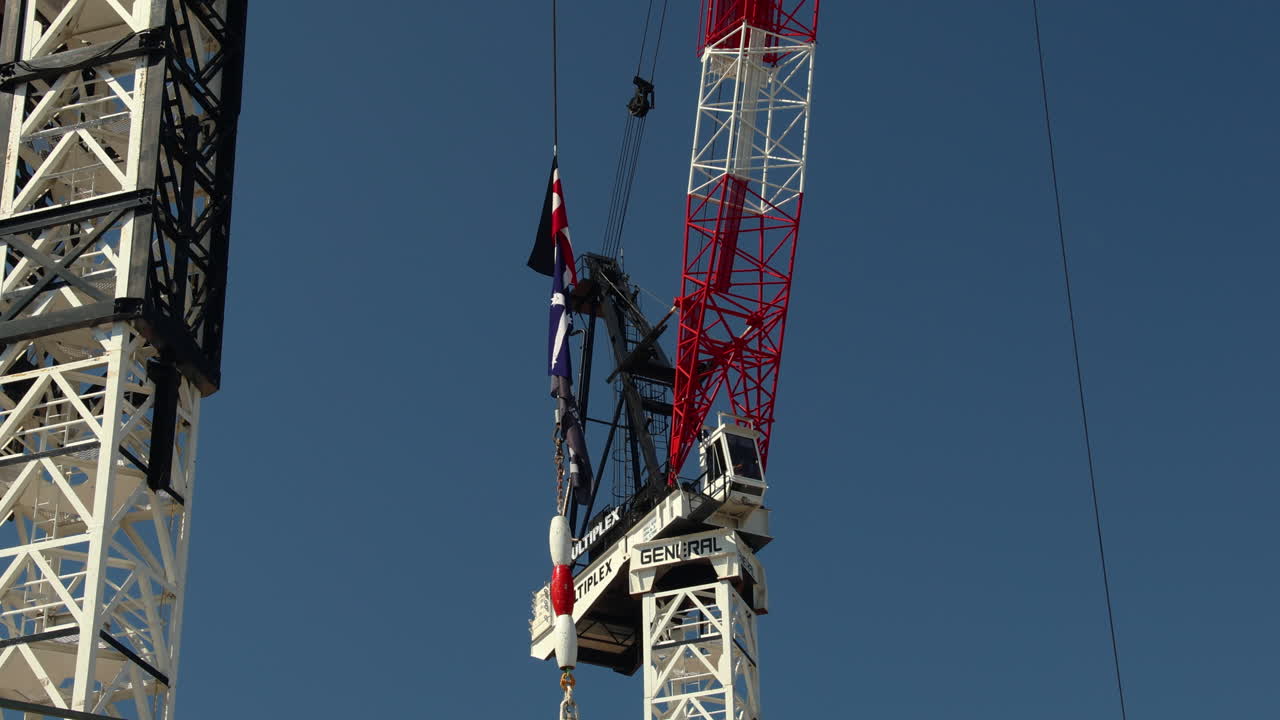 An Australian flag flies on a construction site, symbolizing progress, development, and national pride. This footage is perfect for projects related to construction, infrastructure, urban growth.