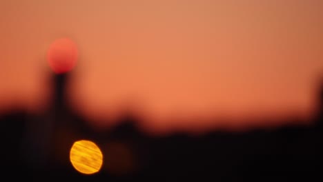 from a blurry image to the camera dollies in to capture a clear and stunning aerial shot of a lighthouse during a sunset in portugal