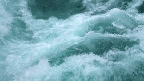 close up shot of the aggressive river leading up to huka falls in new zealand