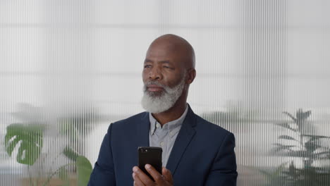 portrait-black-middle-aged-businessman-executive-using-smartphone-enjoying-texting-browsing-messages-sending-email-sms-on-mobile-phone-looking-pensive-in-office