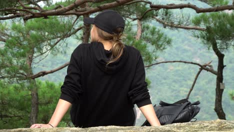 back view of a girl in cap sitting and admiring nature in the achasan mountain