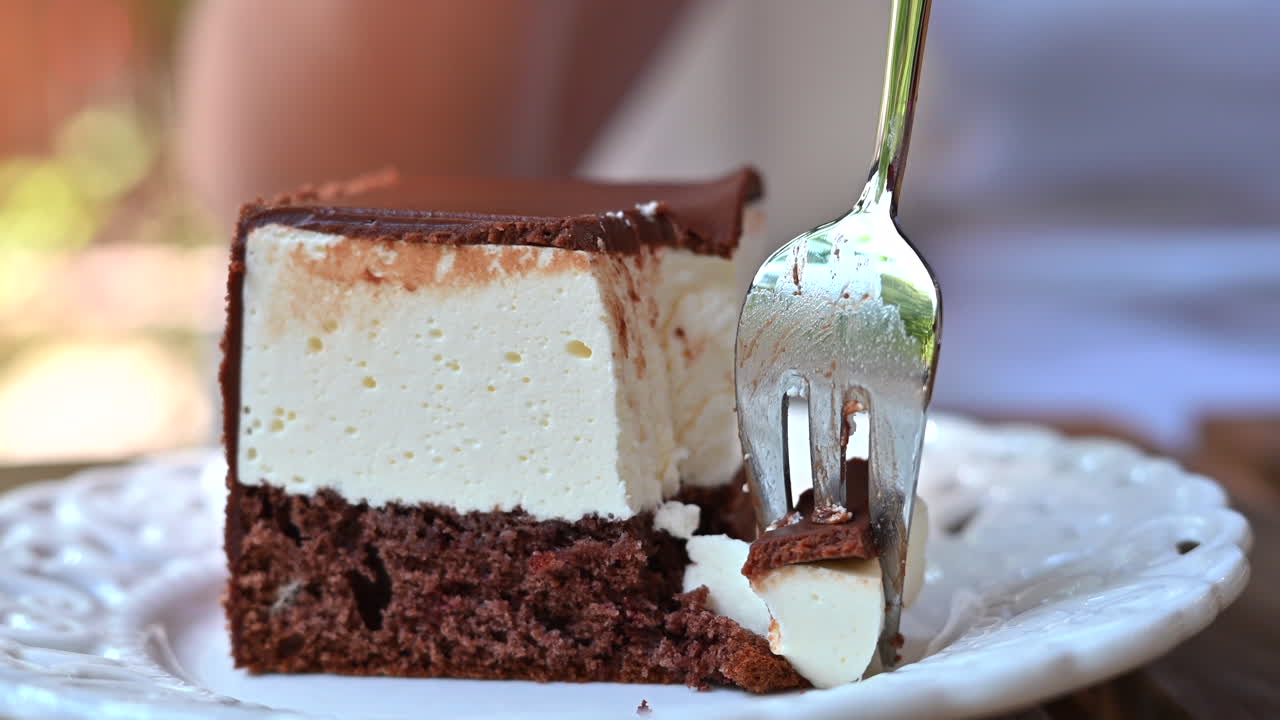 Woman eating a chocolate cake, white and brown, close up