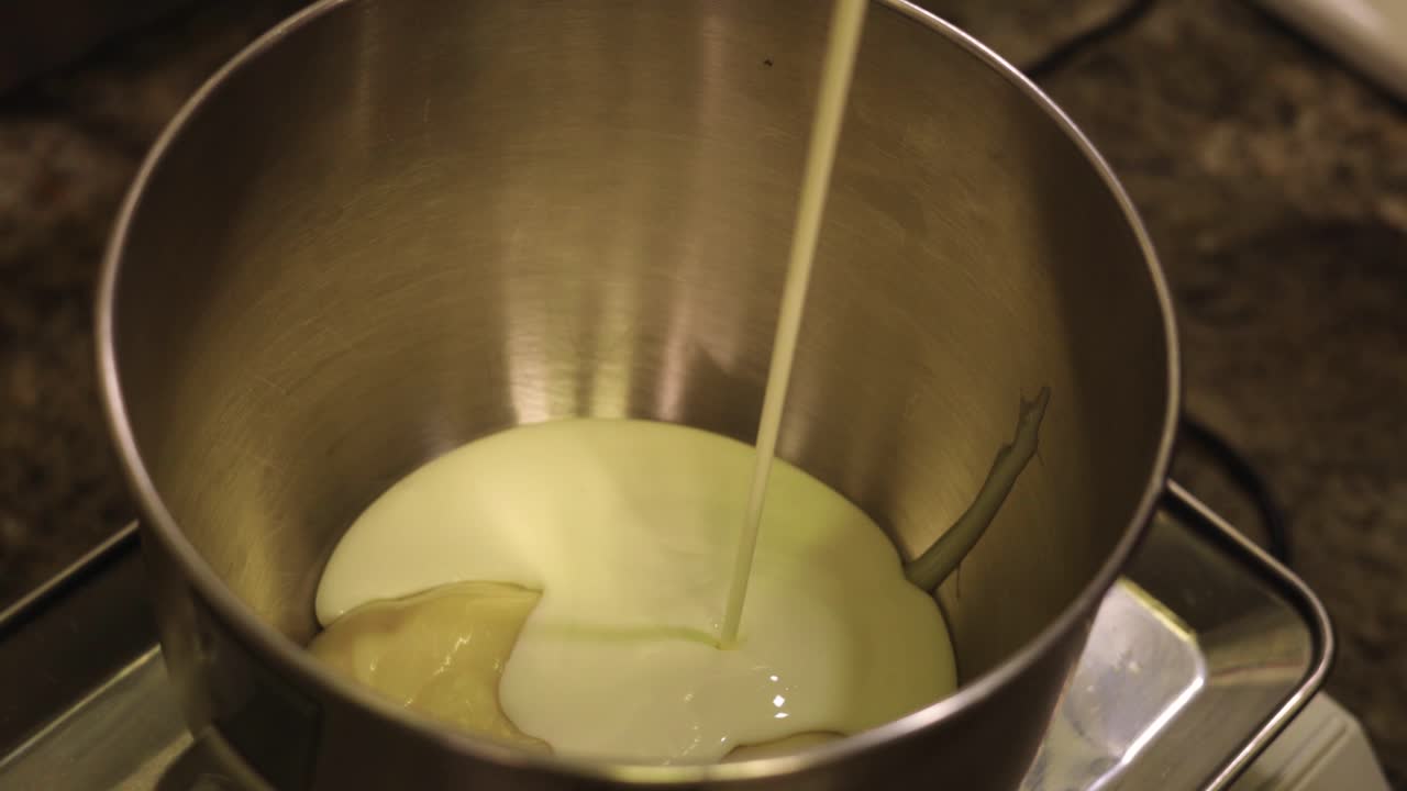 se añade leche a la olla para preparar la masa necesaria para la repostería