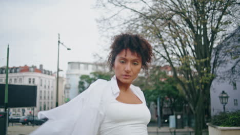 chica tranquila y segura bailando en la calle walk city de cerca. mujer africana moviéndose