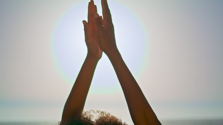 Ragazza yogi con le mani alzate al cielo in posizione Namaste, primo piano. Donna che unisce i palmi.