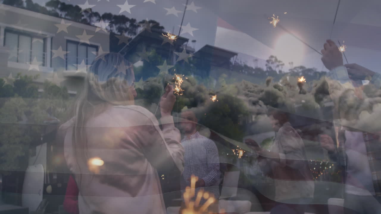 Celebrating with sparklers, people overlaying American flag and fireworks animation